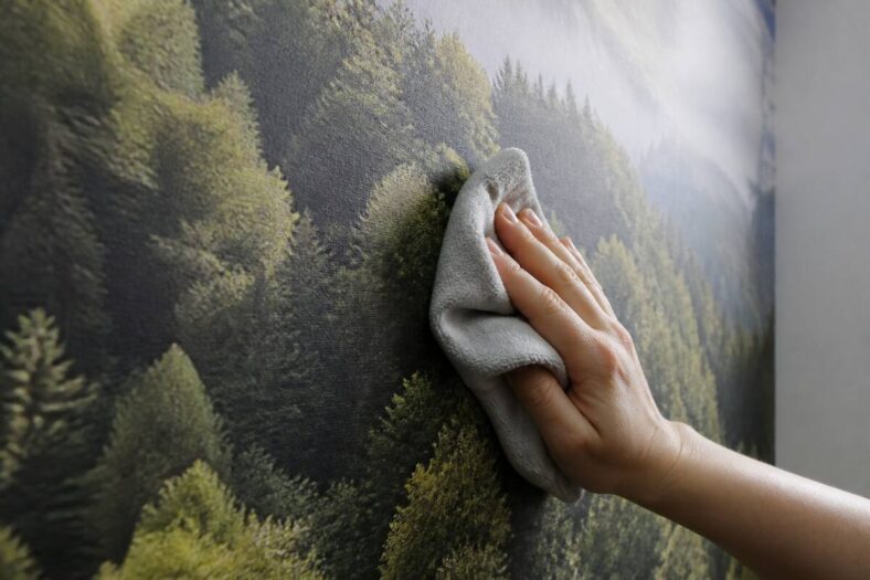 Fotobehang met eigen foto wordt voorzichtig schoongemaakt met een microvezeldoek in een lichte kamer